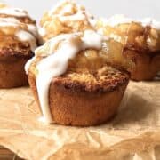 Cinnamon roll apple pies on a brown piece of parchment paper.