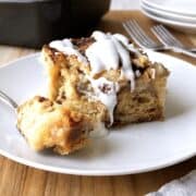 Slice of cinnamon roll dump cake on a white plate.