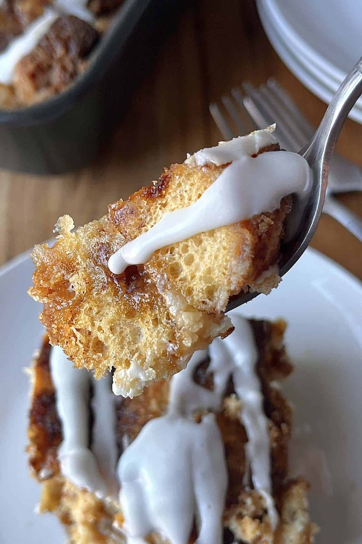 Fork with cinnamon roll dump cake on it.