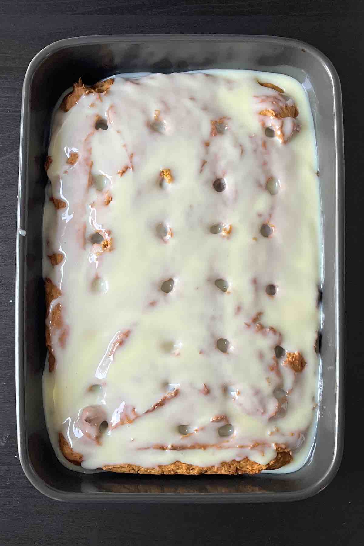 Pumpkin cake with holes in it and sweetened condensed milk poured all over the top.