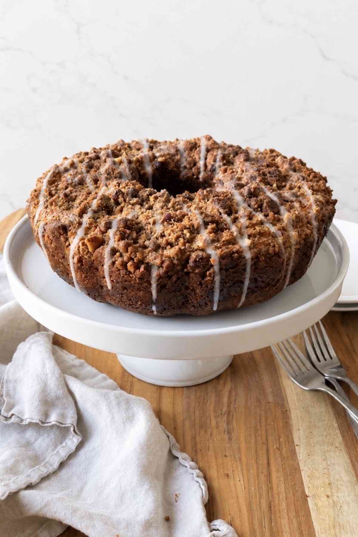 Coffee cake turned onto a cake stand and drizzled with icing.