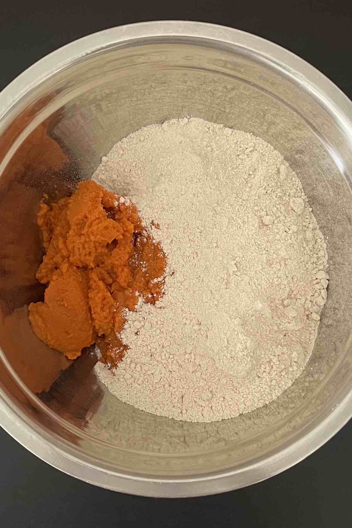 Cake mix and pumpkin puree in a bowl.