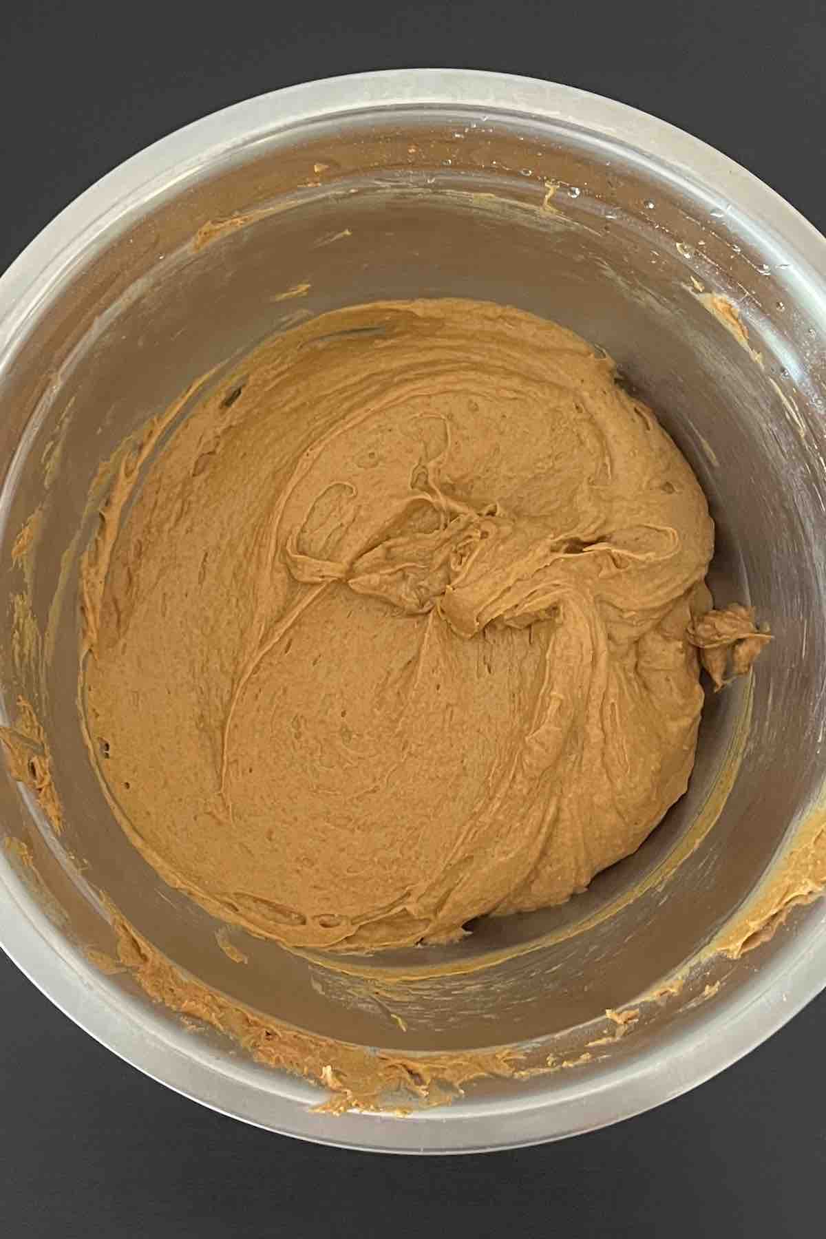 Cake mix, pumpkin, vegetable oil, vanilla and eggs mixed in a bowl.