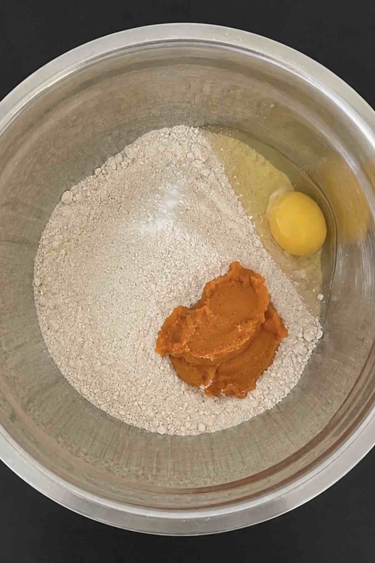 Cake mix, pumpkin, vegetable oil, vanilla and eggs in a bowl.