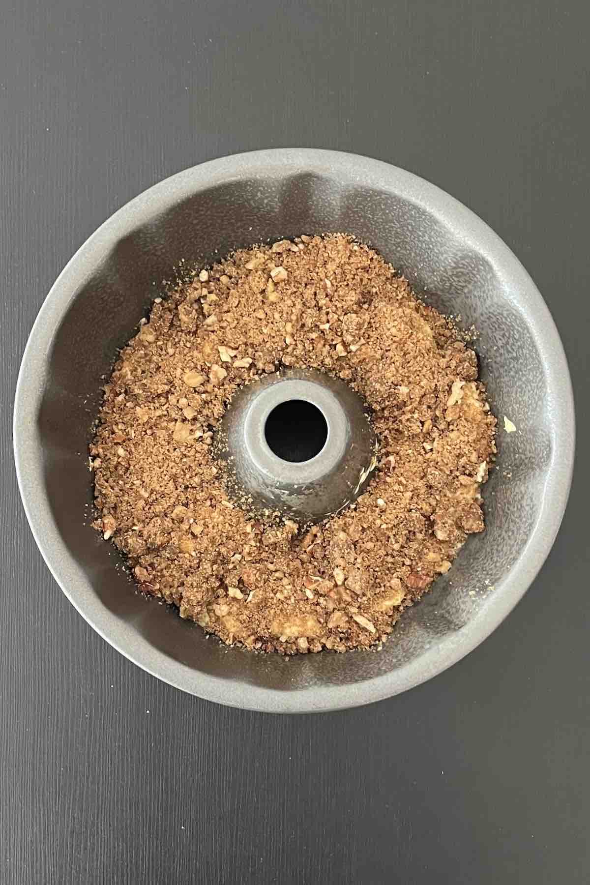 First layer of cake topped with streusel in a bundt pan.