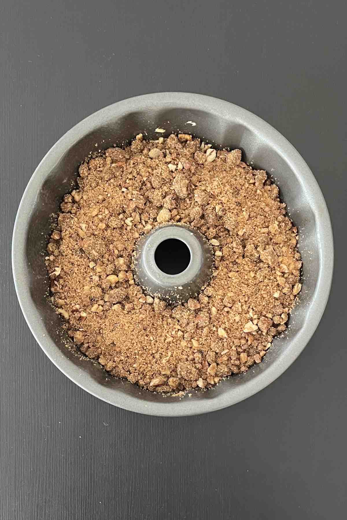 Second layer of cake topped with streusel in a bundt pan.