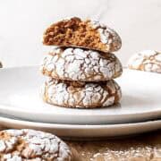 Pumpkin crinkle cookies stacked on a white plate.