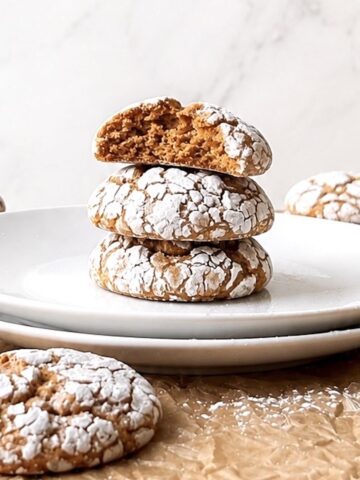 Pumpkin crinkle cookies stacked on a white plate.