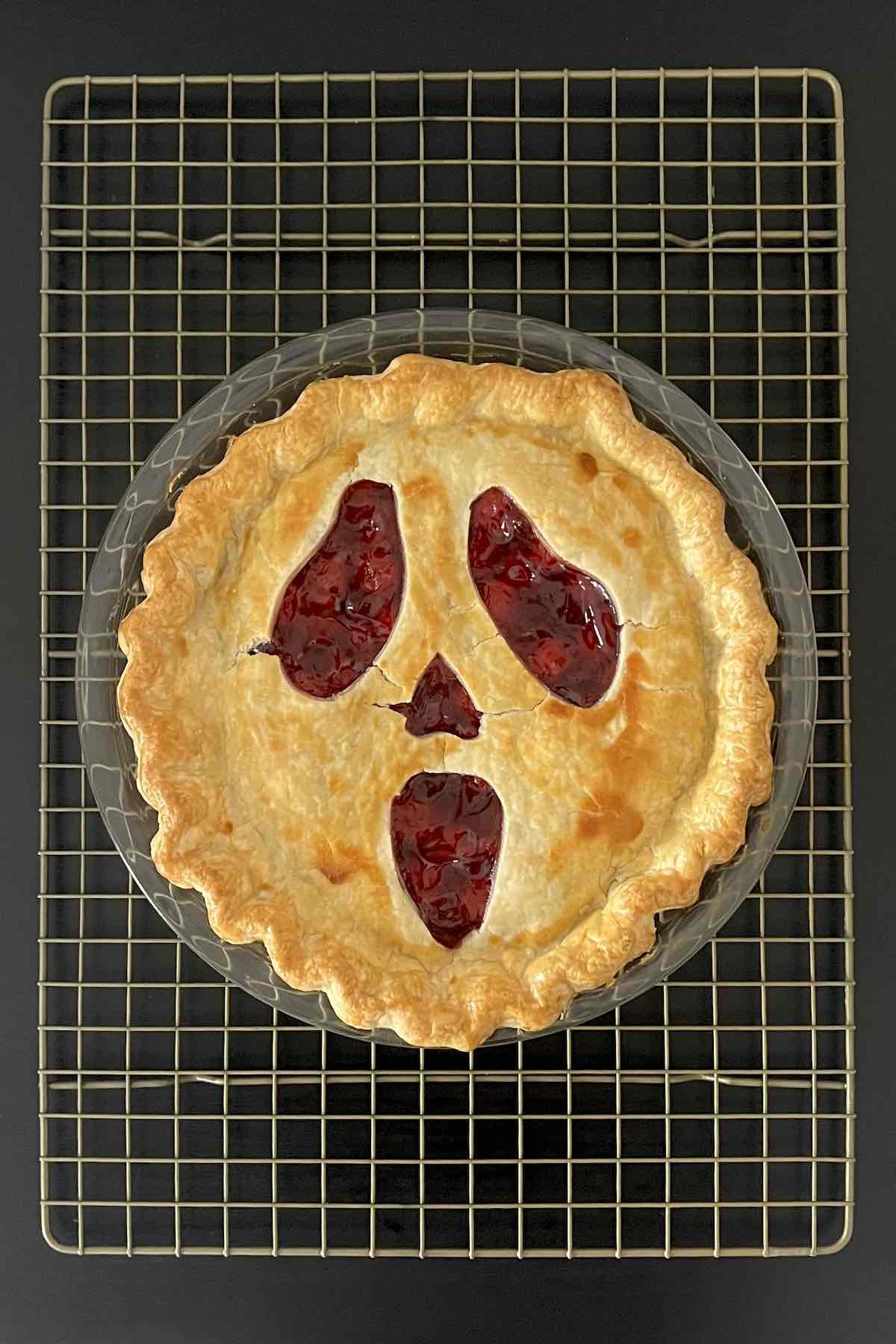 Baked halloween pie on a cooling rack.