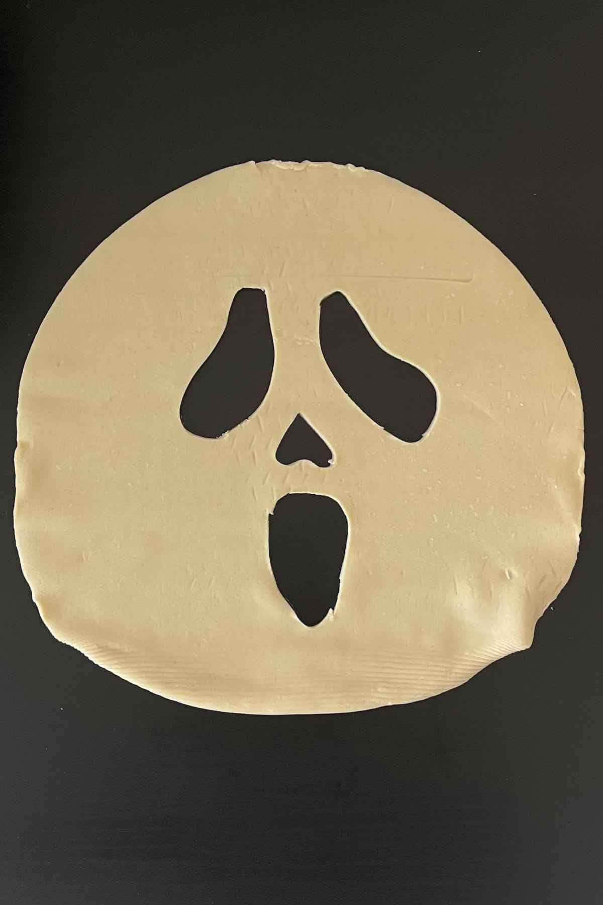 Pie sheet with carved halloween face in it.