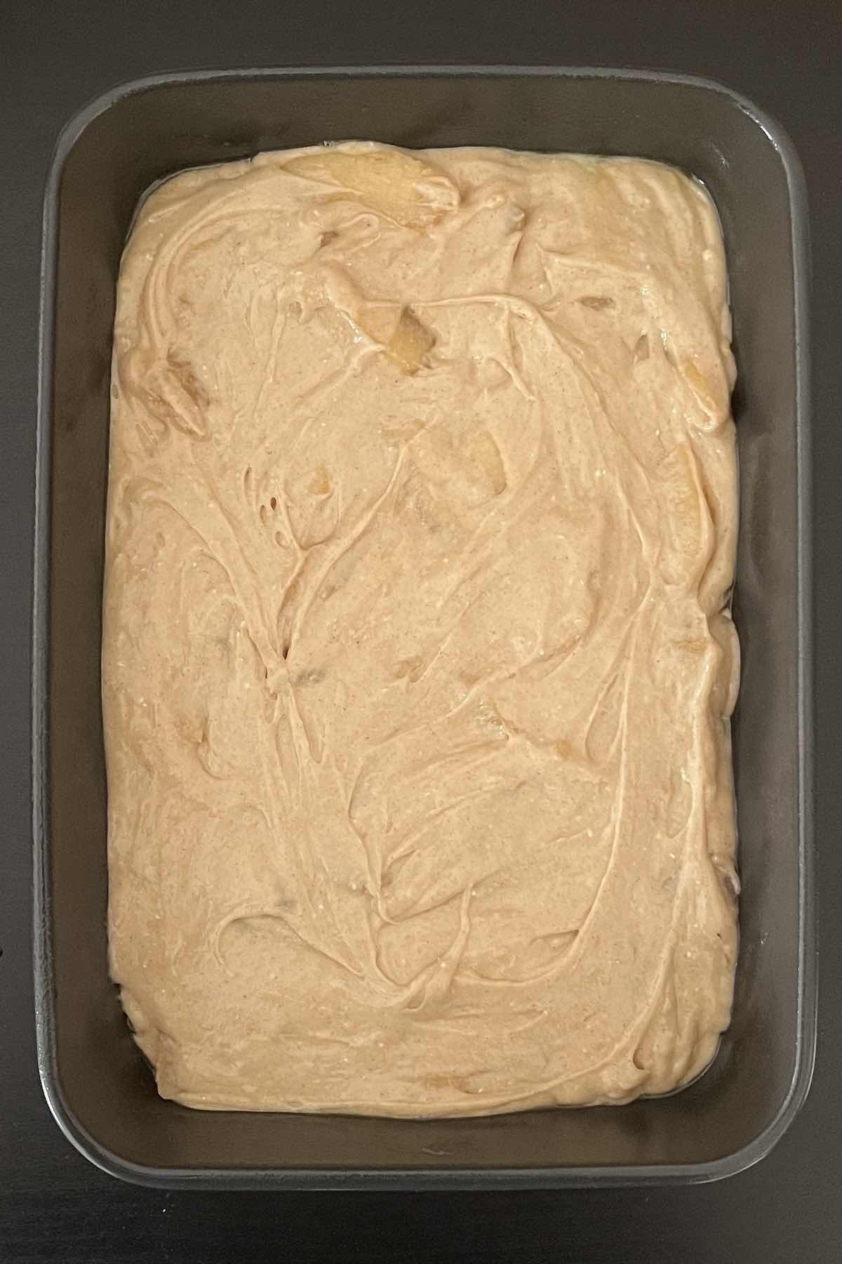 Cake mix, cinnamon, and apple pie filling mixed together in a baking dish.