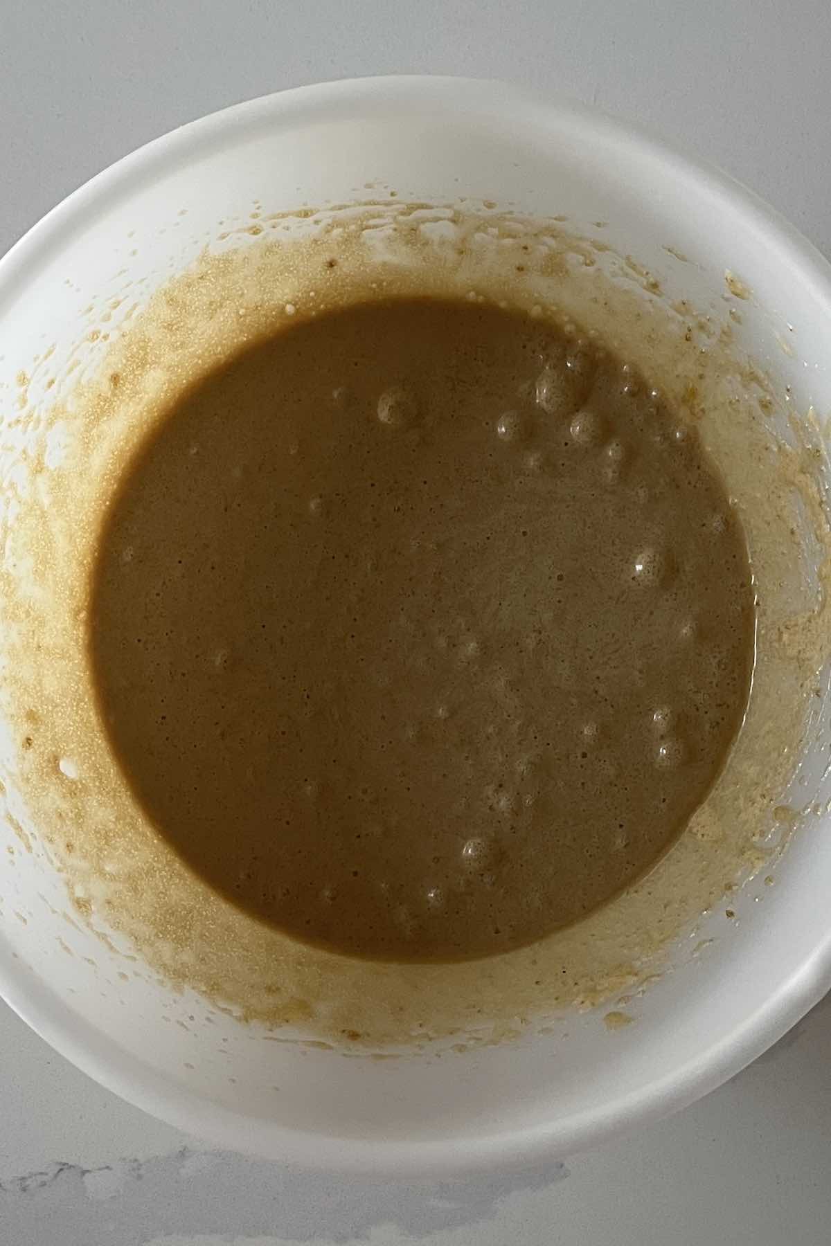 Bowl of butter, brown sugar, corn syrup, vanilla, eggs, and salt mixed together.