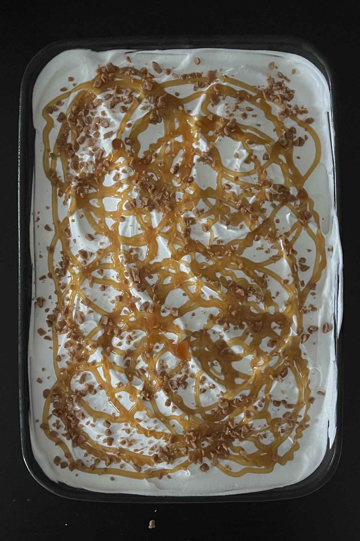 Caramel drizzle and toffee bits sprinkled over the cake.